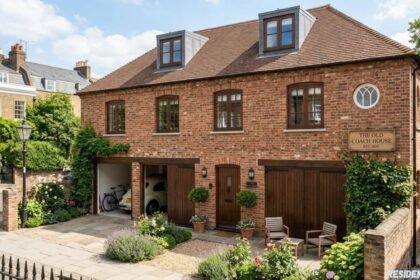 The Old Coach House, a restored brick heritage home with wooden garage doors, landscaped garden, and traditional architectural charm.