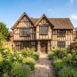 Exterior of Greyfriars House, a historic Tudor-style timber-framed building with a lush walled garden and stone path.