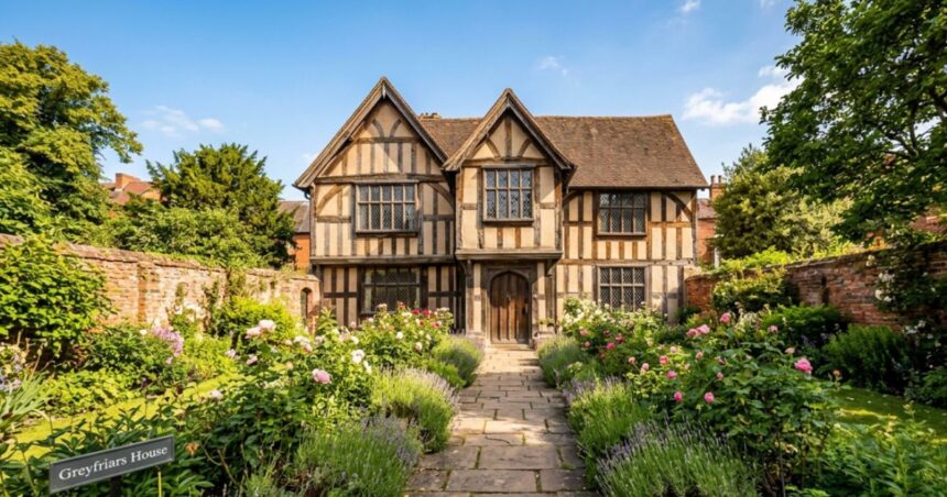 Exterior of Greyfriars House, a historic Tudor-style timber-framed building with a lush walled garden and stone path.