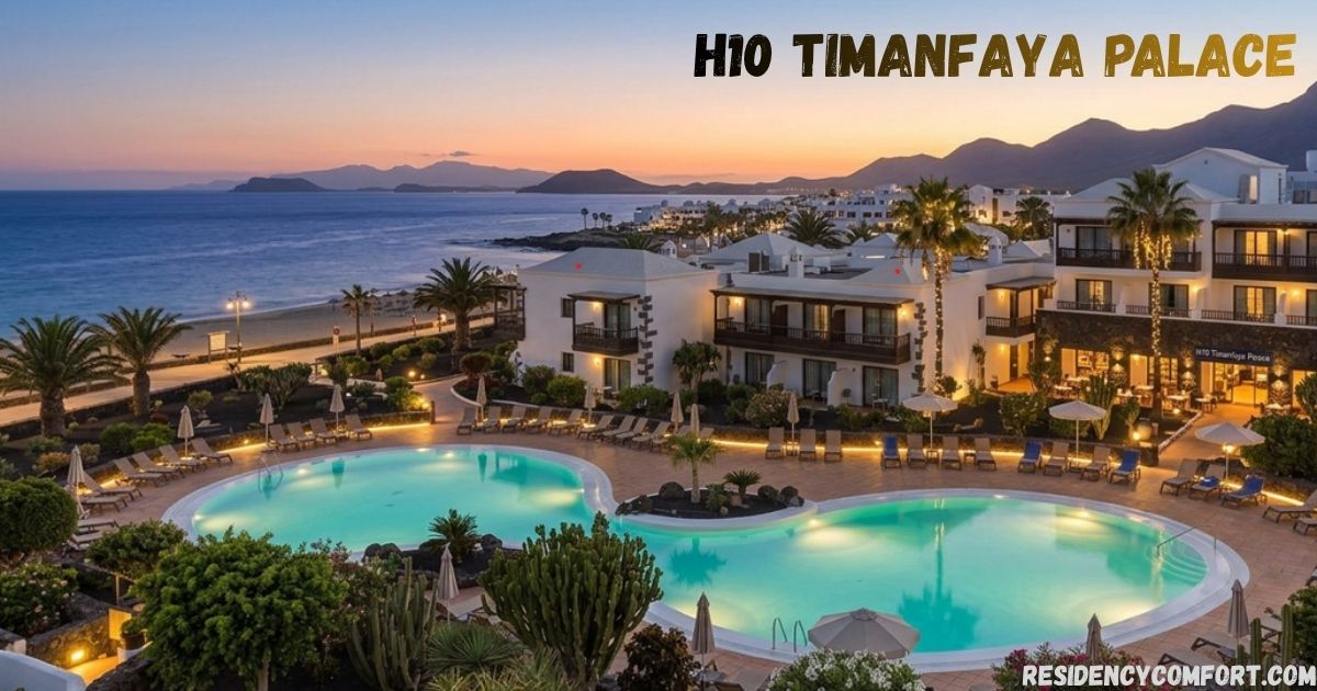 H10 Timanfaya Palace beachfront resort at sunset, featuring illuminated swimming pools, elegant white buildings, palm trees, and stunning ocean views in Lanzarote, Spain.