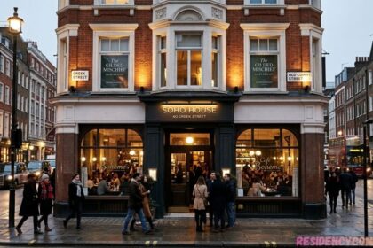 Soho House at 40 Greek Street in London, featuring historic architecture, a busy street, pedestrians, and red double-decker buses.