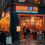 House of Fu ramen restaurant in Manchester city center with vibrant neon signage and outdoor seating.
