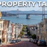 SF Property Tax title over a San Francisco residential street with colorful Victorian homes and the Bay Bridge in the background.